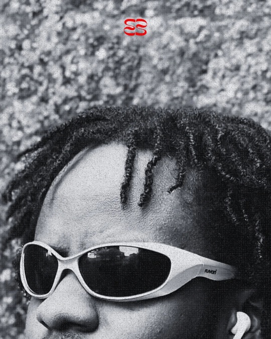 Close-up of a man with braids in white ruvori sunglasses, in black and white.