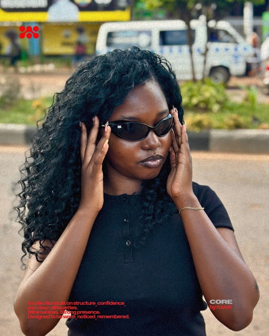 Woman with long curly hair holding both hands to her face, wearing the Black Edition.